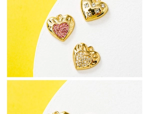 Détail de pendentifs cœur dorés avec texture martelée et zircons roses sertis