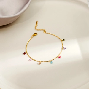 Detail of gold chain bracelet featuring seven vibrant multi-colored zircon pendants