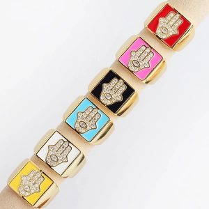 Detail view of colorful enamel Hamsa Hand square rings in various vibrant finishes