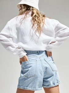 Back view of a white cotton gauze long-sleeve shirt paired with light blue denim shorts