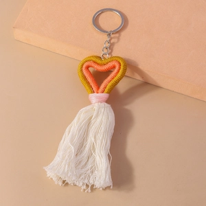 Detail of handmade knitted heart tassel keychains in yellow, pink, and beige tones