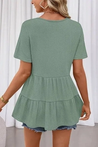 Détails de la texture gaufrée et de l'ourlet à volants de ce haut pour femme vert sauge