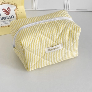 Detail showing the quilted yellow and white candy striped fabric and brand label