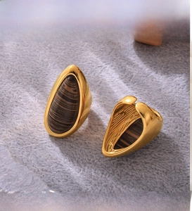 Detail of PVD electroplated gold earrings featuring teardrop wood grain stone inlays
