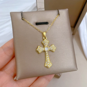 Macro view of a gold-plated titanium cross pendant with full cubic zirconia pave setting