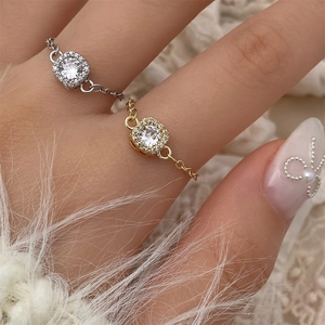 Close-up of adjustable silver and gold square zircon rings on a model's finger