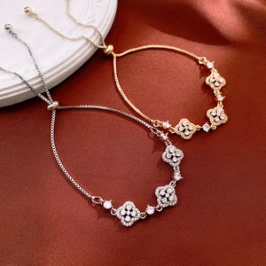 Detail of adjustable four-leaf clover bracelets with shimmering crystals in gold and silver