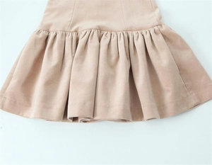 Détail de la robe dos nu abricot montrant l'ourlet plissé et la texture du tissu
