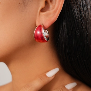 Close-up of model wearing vibrant red resin C-shape hoop earring with silver post