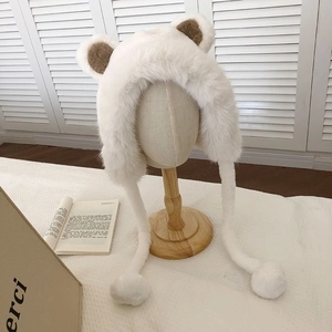 Detailed close-up of the plush white bear ear hat with soft fur texture and brown accents