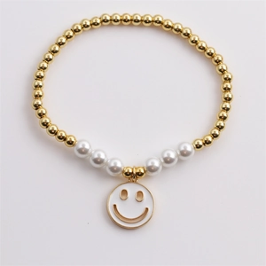 Bracelet chic en perles dorées avec perles blanches et un pendentif visage souriant