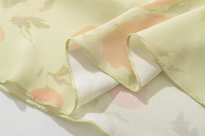 Détail du tissu en mousseline vert clair à fleurs avec bords ondulés et coutures fines