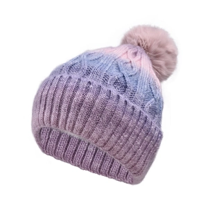 Detail of ombre cable knit winter hat with a fluffy faux fur pom-pom and ribbed cuff
