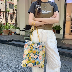 Mannequin portant un sac cabas en toile fleurie avec anses jaunes et grande capacité
