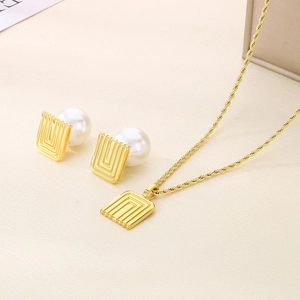 Close-up of gold twist chain necklace and matching square pearl stud earrings set