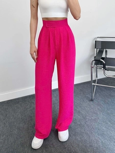 Détail d'un pantalon taille haute à jambes larges rose rouge avec tissu texturé fin