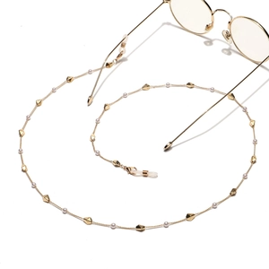 Detail of elegant gold eyewear chain with pearls and geometric metal beads decoration