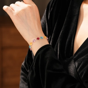 Close-up of elegant bracelet with multi-colored gemstones and claw setting on a wrist