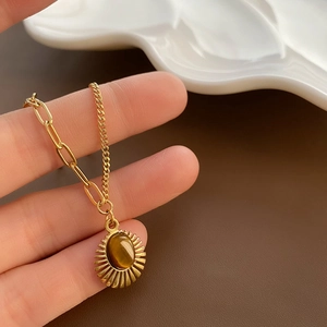 Gold plated tiger eye stone necklace with unique AB chain design on white plate