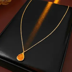 Gold plated Buddha pendant necklace with amber drop on black jewelry display box