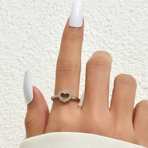 Close-up of minimalist silver heart ring with sparkling cubic zirconia on model's hand
