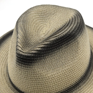 Detailed top view of a woven fedora hat with gradient black spray paint and straw texture