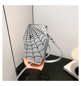 Close-up of a silver reflective spider web bag with a coffin shape and metal strap buckle