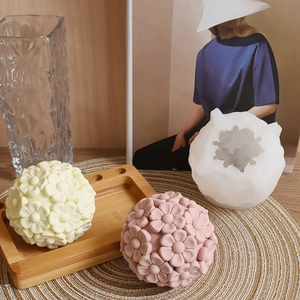 Detailed silicone mold and 3D floral ball candle results on a rustic wooden tray