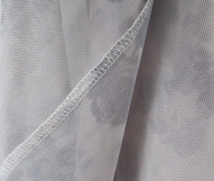 Detailed macro view of the grey mesh fabric texture and high-quality lockstitch seam
