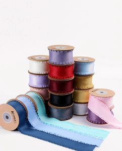 Gros plan de rubans en satin plissé coloré montrant les textures et bords ondulés