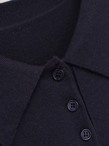 Dettaglio di polo in maglia blu scuro con colletto classico e tre bottoni