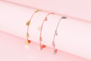 Three elegant anklets in gold, rose gold and silver with clover and bead pendants