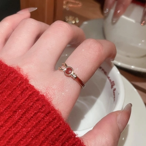 Close-up of gold plated ring with red enamel center and sparkling side stones