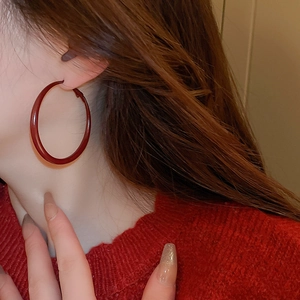 Vintage burgundy geometric hoop earrings worn by a model in a stylish profile shot