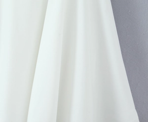 Close-up of smooth white fabric texture and elegant draping on a princess style dress