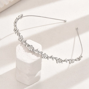 Detailed view of elegant silver metal headband with rhinestone flowers and leaves