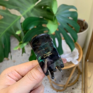 Detail of dark green marble acetate hair claw clip with golden Barrette la France logo