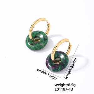 Détail de boucles d'oreilles en acier avec breloques en résine marbrée vert et violet