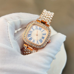 Detail of rose gold square watch with crystal-encrusted strap and blue Roman dial