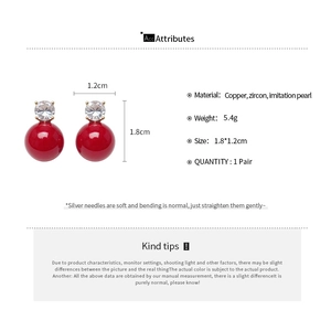 Detailed view of red pearl earrings with zircon inlay and silver needle specifications