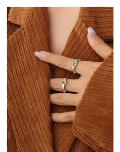 Close-up of silver-toned chain rings in high-quality titanium steel on a model's finger