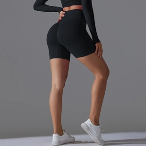 Detail showing high-waist seamless black fitness shorts with peach lift design for women