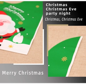 Detail of green Christmas gift bag with festive Santa Claus pattern and Merry Christmas text