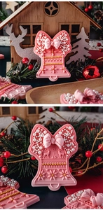 Detail of pink Christmas bell silicone molds featuring bow, snowflake, and reindeer relief