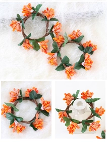 Macro detail of orange festive berry wreath with green leaves and frosted texture