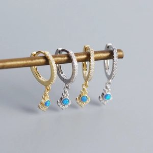 Detail of silver and gold bohemian hoop earrings featuring blue opal and white cubic zirconia