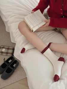 Detail of vintage knit socks with cable texture and elegant burgundy ruffled cuffs