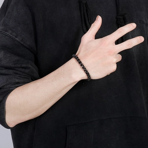 Close-up of a men's matte black titanium steel box chain bracelet worn on the wrist