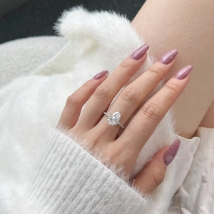 Macro shot of luxury S925 silver pear-cut diamond ring on model with velvet background