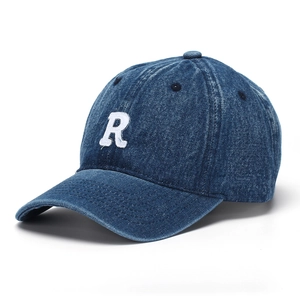 Detailed close-up of white embroidered R letter on dark blue washed denim baseball cap